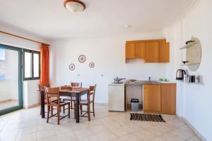 a kitchen and dining room with a table and chairs at Fronis Studios in Karpathos
