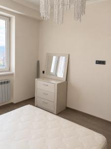 a white room with a dresser and a mirror at White Residency in Yerevan