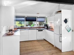 a kitchen with white cabinets and a refrigerator at 0416-Romo-Dyssebjergvej-13 in Høm