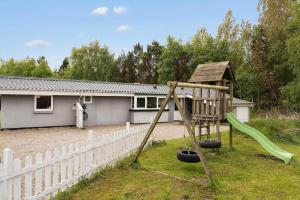 a playground with a slide in front of a house at 0416-Romo-Dyssebjergvej-13 in Høm