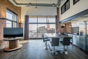 a kitchen with a television and a table with chairs at Le Venise Factory in Martigues