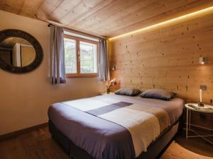 a bedroom with a bed in a log cabin at Chalet 4★, 15 pers, La Clusaz, sauna, centre village, 7 chambres - FR-1-304-177 in La Clusaz