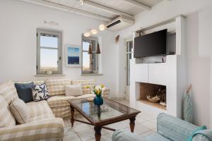 a living room with a couch and a fireplace at Villa Kohyli by Mediterà in Isterni
