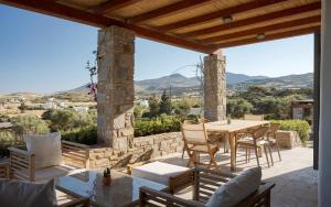a patio with a table and chairs and a view at Villa Kohyli by Mediterà in Isterni