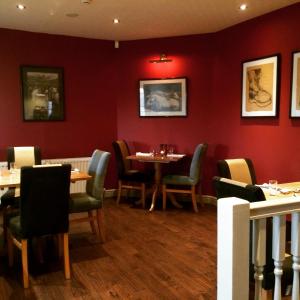 comedor con paredes rojas, mesas y sillas en The Craven Arms en Settle