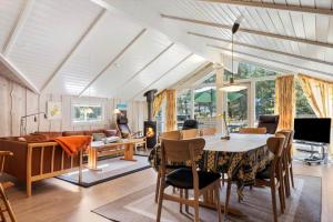 a dining room and living room with a table and chairs at 0046-Romo-Trinnesvej-17 in Høm
