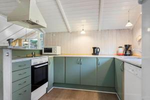 a kitchen with blue cabinets and white appliances at 0046-Romo-Trinnesvej-17 in Høm +22 photos