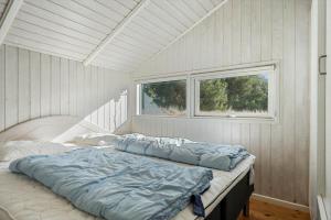 a bed in a white room with a window at 0046-Romo-Trinnesvej-17 in Høm