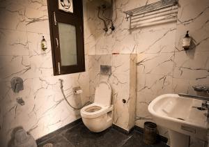 a bathroom with a toilet and a sink at The Milford Noida in Noida
