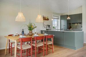 a kitchen with a wooden table and red chairs at 381-Harboore-Slettevej-32 in Harboør