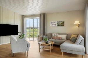 a living room with a couch and a tv at 381-Harboore-Slettevej-32 in Harboør