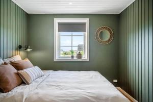 a green bedroom with a bed and a window at 381-Harboore-Slettevej-32 in Harboør