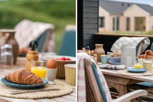 a table with a breakfast of bread and eggs and orange juice at 381-Harboore-Slettevej-32 in Harboør +22 photos