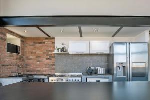 a kitchen with stainless steel appliances and a brick wall at Le Venise Factory in Martigues