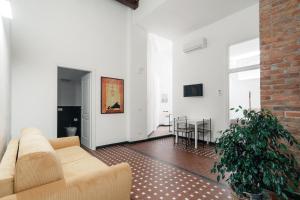 a living room with a couch and a brick wall at Appartamento Letterario e Musicale - Art & Design in Grosseto