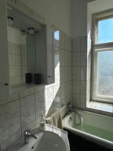 a bathroom with a sink and a tub and a window at Ultra Central Cluj-Napoca in Cluj-Napoca