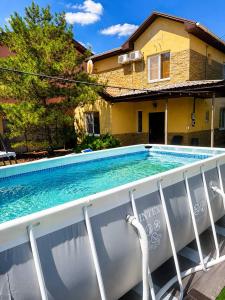 a swimming pool in front of a house at Sunny House Seaside in Zatoka