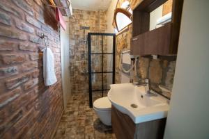 a bathroom with a sink and a brick wall at Qekik Boutique Kazdağları in Arıklı