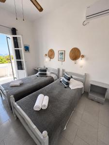two twin beds in a room with a window at Panagiotis Rooms in Naousa