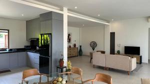 a kitchen and living room with a table and chairs at Villa Lombok Surga Kedua Setangi in Mangsit