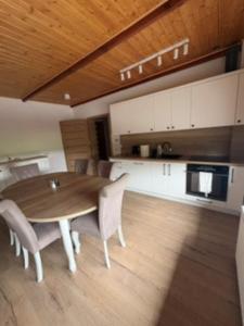 a kitchen and dining room with a wooden table and chairs at Apartament u Anitki in Trzebnica
