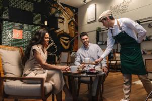 a man and woman sitting at a table in a coffee shop at Ibis Abu Dhabi Gate in Abu Dhabi +48 photos