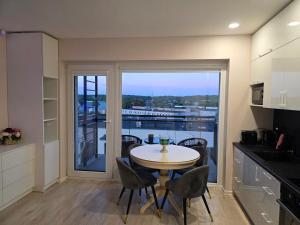 a kitchen with a table and chairs and a large window at Nemunas Riverside in Kaunas