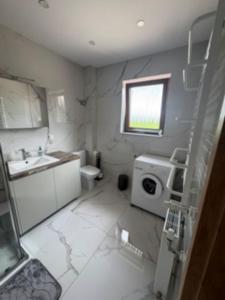a white bathroom with a sink and a microwave at Apartament u Anitki in Trzebnica +1 photo