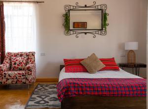 a bedroom with a bed with a mirror and a chair at Miti Retreat Nanyuki in Naro Moru