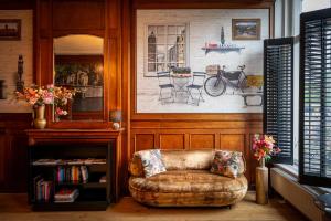 a chair in a room with a picture of a bicycle at Hotel Mansion in Amsterdam