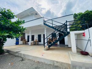 a house with a staircase in front of it at NRT Beach Hotel in Trincomalee