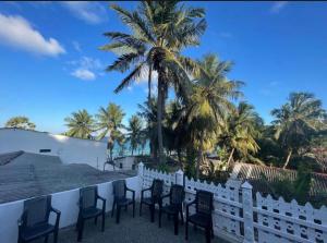 a row of chairs on a balcony with a palm tree at NRT Beach Hotel in Trincomalee