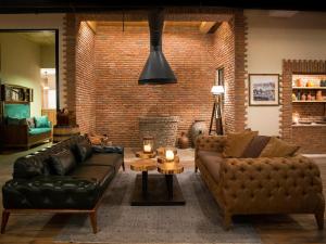 a living room with two leather couches and a brick wall at Museum Hotel in Tbilisi City