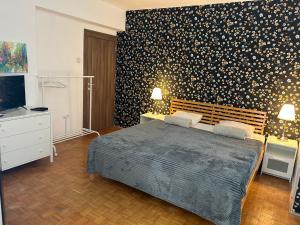 a bedroom with a large bed with a black wall at Sokolov Apartment in Smederevo