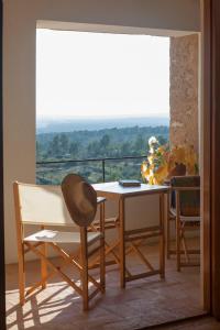 a table and chairs in a room with a view at Aldea Roqueta Hotel Rural in Els Ibarsos +55 photos