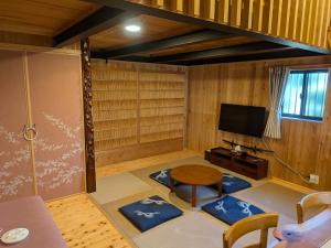 a living room with a table and a tv at くまの蔵 Kumanokura inn Storehouse in Shingū