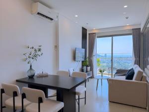 a dining room and living room with a table and chairs at The Song Vung Tau Apartment - Căn Hộ Du Lịch Biển Vũng Tàu in Xã Thang Tam