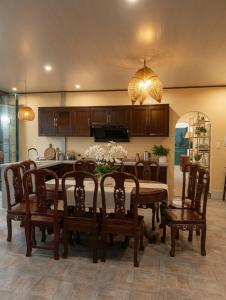 a dining room with a table and chairs and a kitchen at Pham's Homestay in Île de Trà Cổ +12 photos