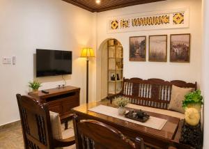 a living room with a dining table and a television at Pham's Homestay in Île de Trà Cổ
