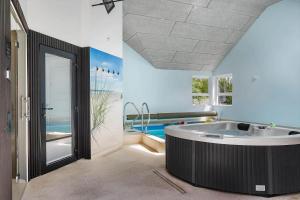 a large bathroom with a tub and a pool at 0498-Romo-Godthabsvej-29 in Høm