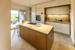 a kitchen with white cabinets and a counter with a bar at Elbblick Premium-Apartment zentral in Dresden in Dresden
