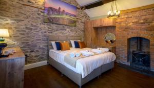 a bedroom with a bed and a brick wall at Three Eagles Hotel&Restaurant and Garden Bar in Llangollen +15 photos