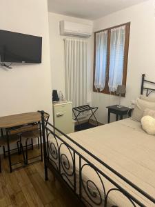a bedroom with a bed and a desk and a television at B&B Il Castello di Alberico in Cotignola