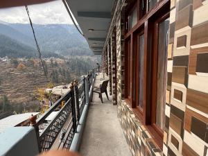 a balcony of a building with a view of the mountains at Rock View in Kulu