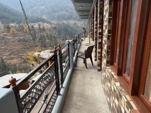 a balcony of a building with a view of the mountains at Rock View in Kulu