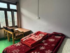 a bedroom with a bed with a red blanket on it at Rock View in Kulu