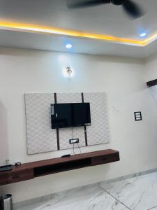 a flat screen tv on a wall in a room at Shaahi Resort Harda in Bhunās