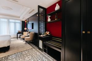 a bedroom with a bed and a red wall at Brilliant Jade Suites in Hanoi