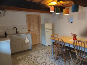 a kitchen with a table and chairs and a refrigerator at Štalca in Bušinja Vas +11 photos