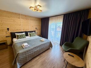 a bedroom with a bed and a green chair at Chokolate house in Bukovel
